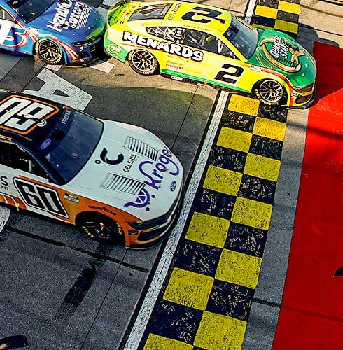 TALLADEGA, ALABAMA - APRIL 27: Austin Cindric, driver of the #2 Menards/Quaker State Ford, takes the checkered flag to win the NASCAR Cup Series Jack Link's 500 at Talladega Superspeedway on April 27, 2025 in Talladega, Alabama. (Photo by Logan Riely/Getty Images)