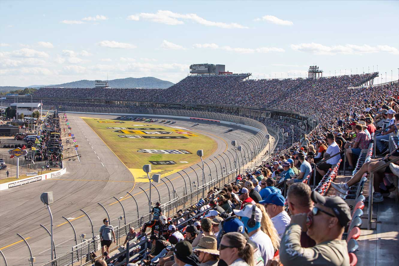 Packed Talladega Superspeedway grandstands beneath the 'THIS IS TALLADEGA' tower during race weekend.